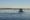 A boat on the Potomac River heading toward a bridge on a calm, clear day.